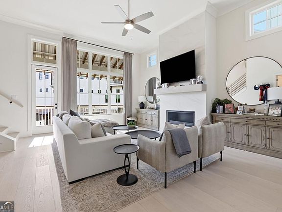 Living room with fireplace, tall windows and seating